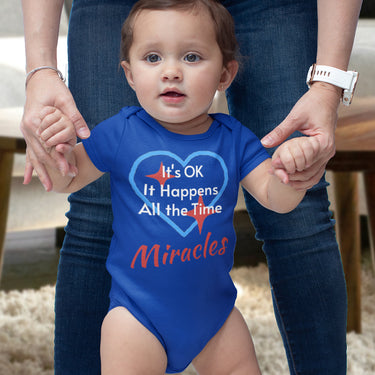 Bella+Canvas baby onesie with “Miracles Happen” design and uplifting message, soft cotton, envelope neck and snap closure, Christian apparel for infants and family matching, baby girl in blue onesie